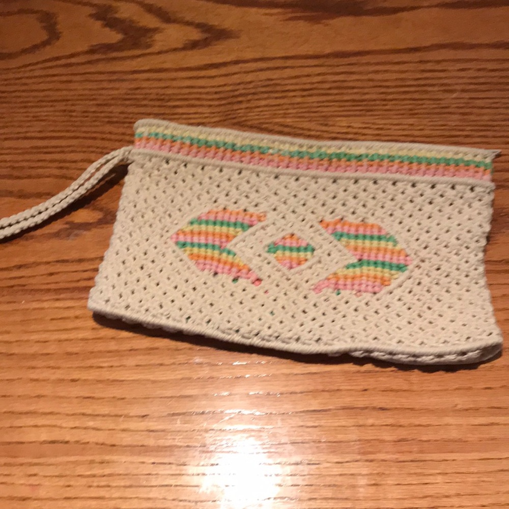 Macrame clutch purse with wrist strap. One large compartment with pocket.